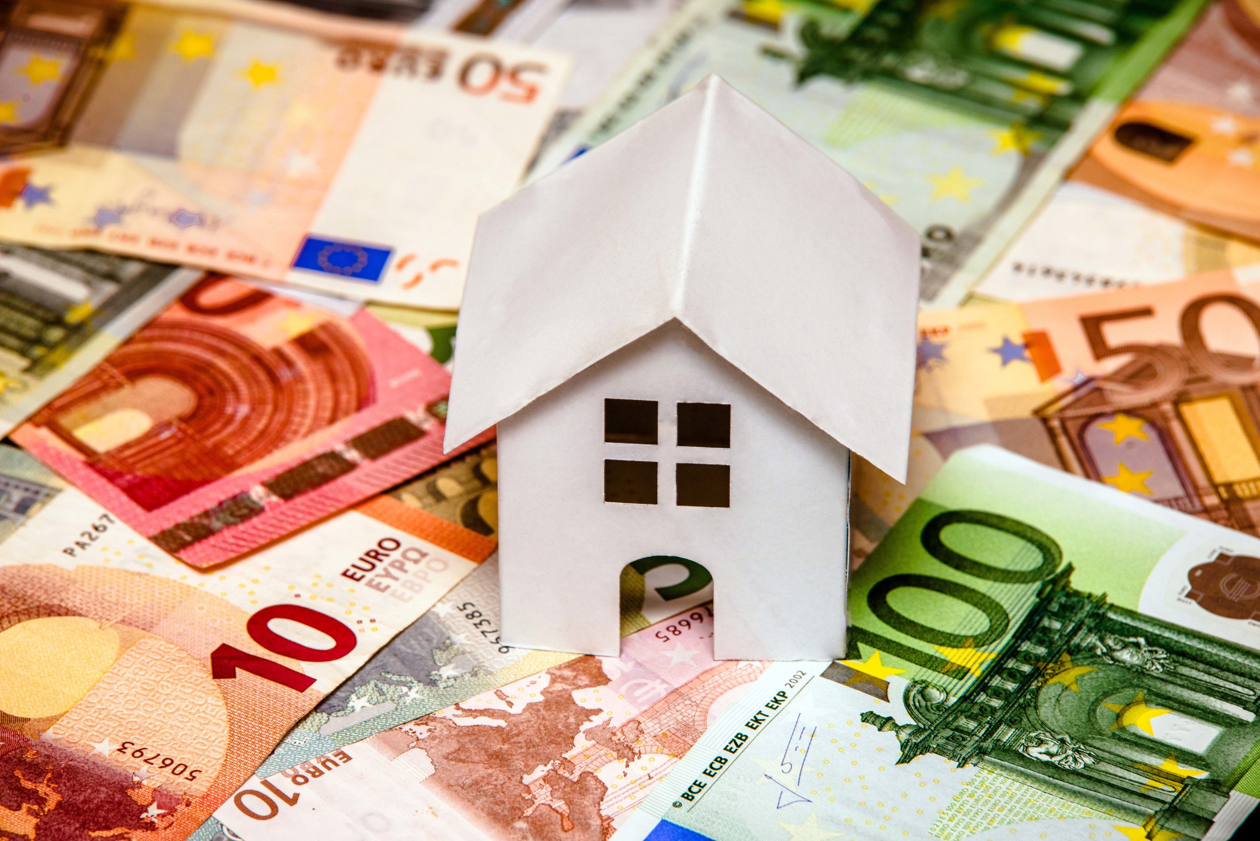 Modell-Haus und Geldscheine: Symbolbild für Immobilienrecht