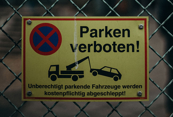 Schild "Parken verboten!" an einem Zaun in Fürth. Bekommt man ein Bußgeld, kann man sich mit einem Anwalt für Verkehrsrecht wehren.