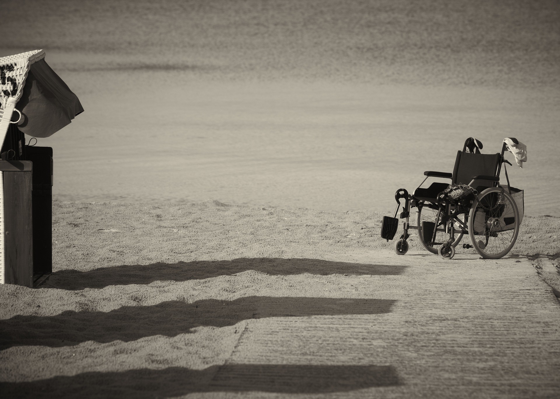 Rollstuhl am Strand: Wenn die Berufsunfähigkeitsversicherung beispielsweise bei einer schweren Radikulopathie nicht zahlt, braucht man einen guten Anwalt.